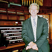 [Gordon Turk seated at the console of the Robert Hope-Jones pipe organ.]