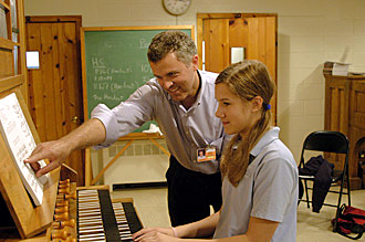 [Tom G. Bara works with organist Caroline Robinson.]